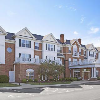 A multi-story brick residential building with white trim and numerous windows.