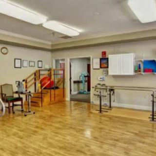 A well-equipped physical therapy room with exercise equipment and supportive tools for rehabilitation.