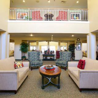 A spacious, well-decorated living room with sofas and a coffee table, featuring a two-story layout.