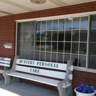 A bench labeled 'Meyers Personal Care' outside a brick building with a large window.