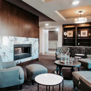 A modern living room with a cozy fireplace and elegant seating area.