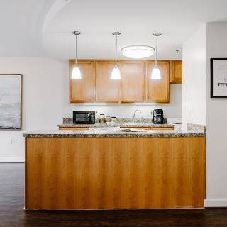 Modern kitchen with wood cabinets and pendant lighting.