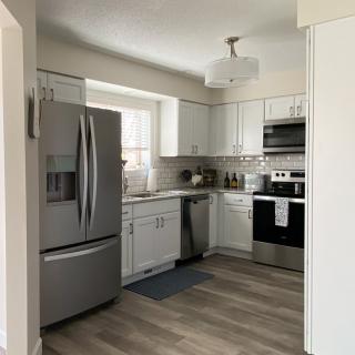 A modern kitchen with stainless steel appliances and white cabinets.