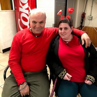Two individuals dressed in red, enjoying a cheerful moment together.