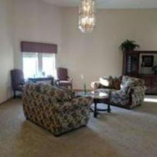 A spacious living room with comfortable seating and a chandelier.