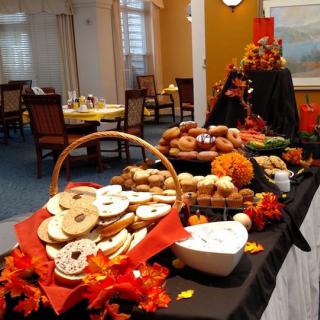 A festive autumn-themed dessert buffet with cookies and doughnuts, adorned with seasonal decorations.