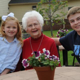 A joyful moment shared between a grandmother and her grandchildren in a beautiful outdoor setting.