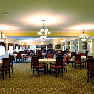 Elegant dining room with multiple tables and chandeliers.