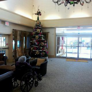 A cozy lobby adorned with a festive Christmas tree, featuring seating and accessible options.