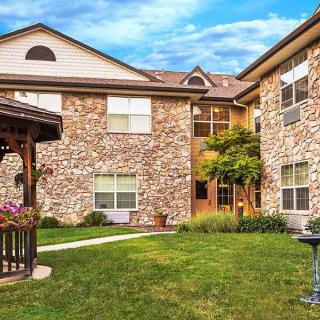 A residential building with a stone facade and a well-maintained courtyard featuring a gazebo.