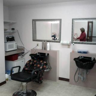 An interior view of a barbershop with chairs and mirrors.
