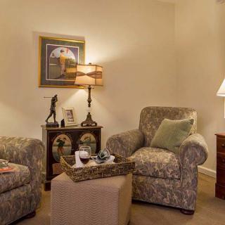 A cozy living room with patterned armchairs, soft lighting, and decorative accents.