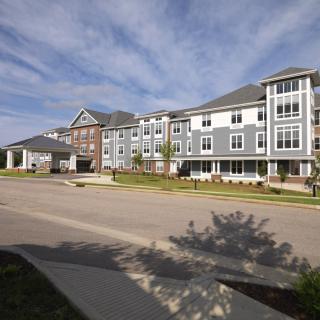 A modern residential apartment building under a clear blue sky.
