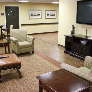A cozy lobby area with comfortable seating and a large television.