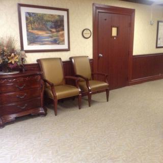 A cozy waiting area with chairs and artwork on the wall.