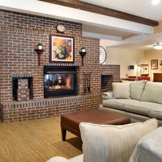 A cozy living room featuring a brick fireplace and comfortable seating.