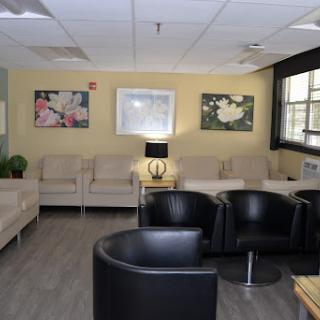 A cozy waiting room featuring comfortable seating, modern decor, and artwork on the walls.