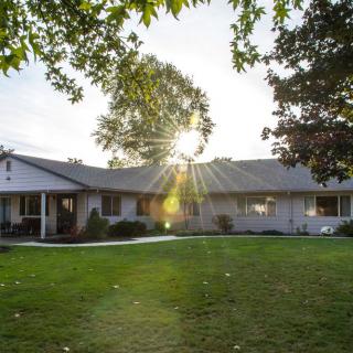 A suburban house with a well-maintained lawn during sunset.