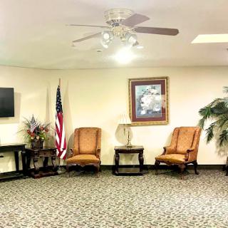 A cozy waiting room featuring comfortable chairs, a television, and decorative elements.