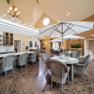 A spacious and modern dining area with tables, chairs, and interior umbrellas.
