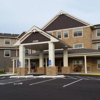 Front view of a hotel with a welcoming entrance and parking area.