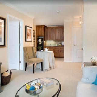 A cozy living room with a small dining table leading into a compact kitchen.