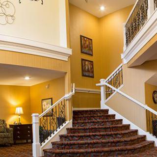 A cozy interior featuring a carpeted staircase and warmly decorated living area.