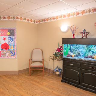A cozy living room featuring a vibrant aquarium, comfortable seating, and colorful wall decor.