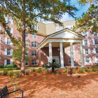 A residential building surrounded by trees with a welcoming entrance.