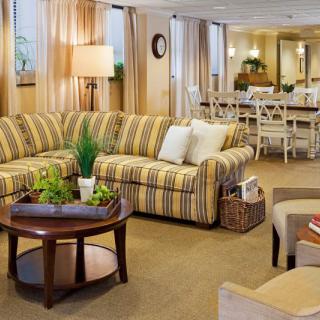 A cozy living room with a striped sofa and a coffee table, featuring elegant interior design elements.