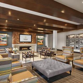 A modern lounge with comfortable seating and a cozy fireplace.