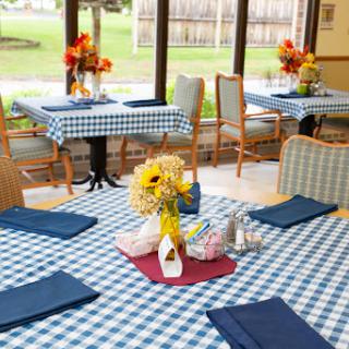A cozy dining area with checkered tablecloths and floral decorations, inviting guests to enjoy their meals.