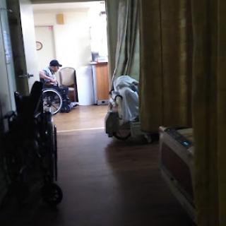 A glimpse into a hospital room showing a patient in a wheelchair.