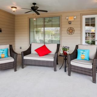 A cozy outdoor patio with wicker furniture and colorful cushions.