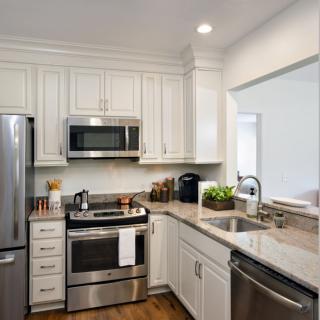 A modern kitchen with stainless steel appliances and white cabinets.