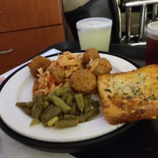 A hearty meal featuring pasta, fried bites, green beans, and garlic bread.