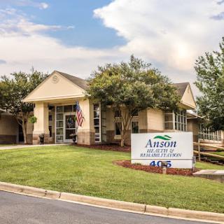 Exterior view of a healthcare facility with signage and landscaped surroundings.