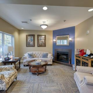 A cozy living room with a sofa set, coffee table, fireplace, and decorative artwork.