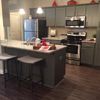 Modern kitchen with island and stainless steel appliances.