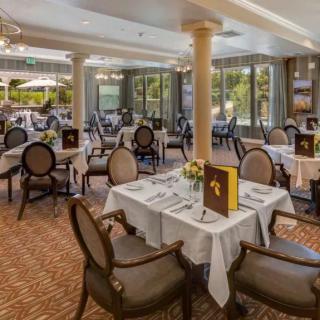 An elegant dining room with neatly arranged tables and chairs, featuring menus and a pleasant ambiance.