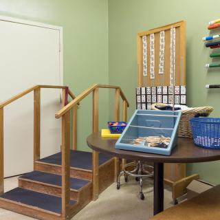 A physical therapy room equipped with stairs and various rehabilitation tools.