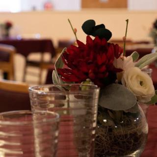 A cozy restaurant table with a floral centerpiece and drinking glasses.