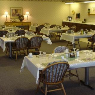 An empty restaurant dining room with tables set for service.
