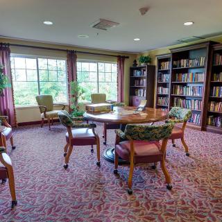 A cozy library reading room with bookshelves and comfortable seating.