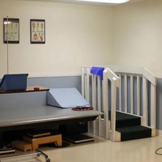 A physical therapy room with exercise equipment and stairs for rehabilitation exercises.