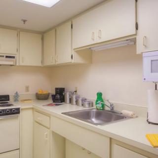 A compact kitchen with cream-colored cabinets and a countertop.