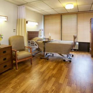 A well-organized, clean hospital room featuring a patient bed and comfortable furniture.