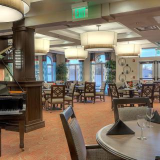 An elegant restaurant dining area with neatly arranged tables and chairs, complemented by tasteful lighting and decor.