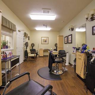 An empty hair salon interior with styling chairs and equipment.