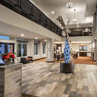 A modern hotel lobby featuring stylish decor, an art sculpture, and seating areas.